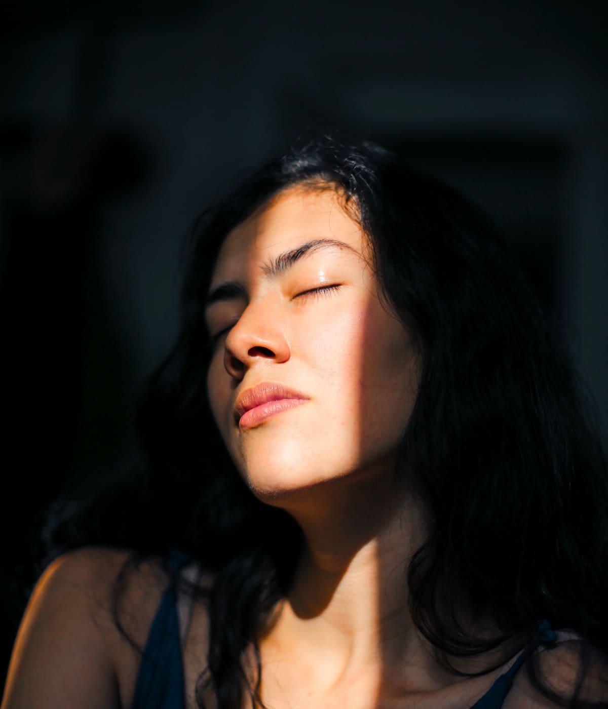 Femme apaisée, les yeux clos dans la lumière du matin
